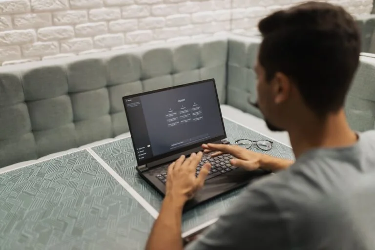 Professional using AI decision intelligence software on laptop in modern workspace.