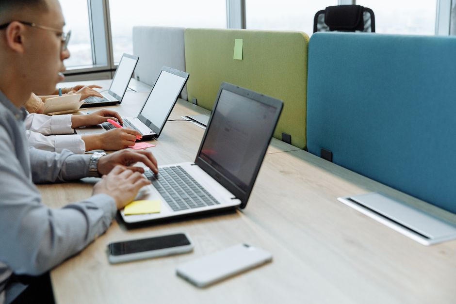 Business team using laptops for AI decision making in a modern workspace.